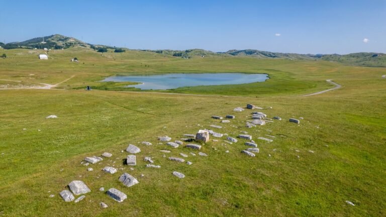 Mountain Fish Lake is surrounded by pastures and clouds.